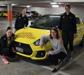 Pulse players standing in front of a Suzuki Swift Sport